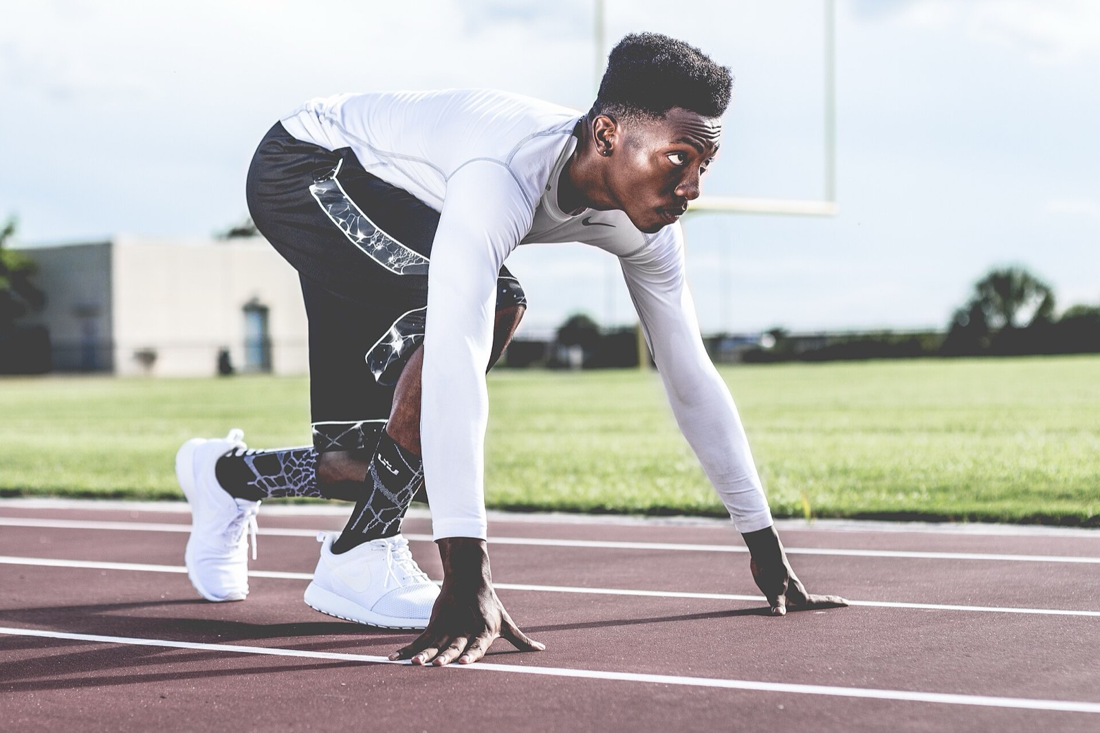 Coureur à pied en plein effort sur une piste d’athlétisme.