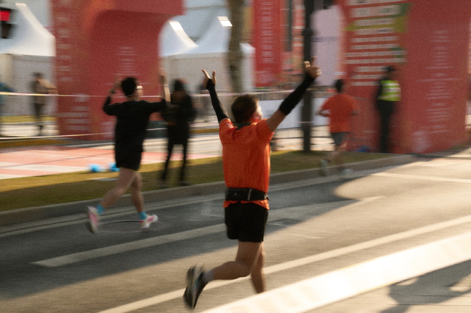 Coureur franchissant l’arrivée d’un marathon, bras levés.