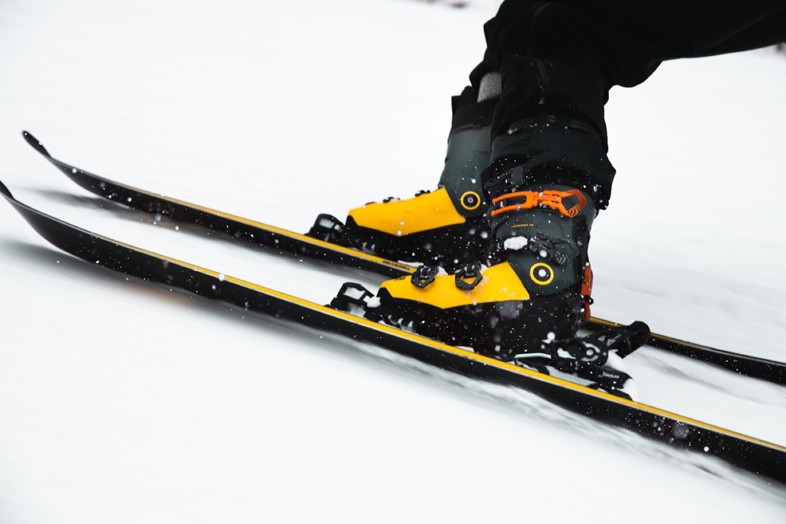 Chaussures de ski techniques de couleur vive en pleine descente sur la neige.