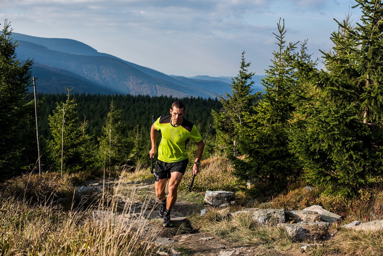 Coureur de trail progressant sur un sentier de montagne.