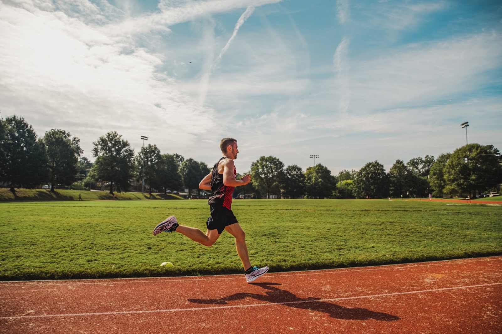 Athlète en plein effort de course sur une piste d’athlétisme.